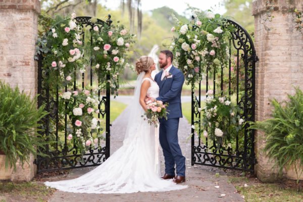 Bride and groom standing by the open gates - Brookgreen Gardens