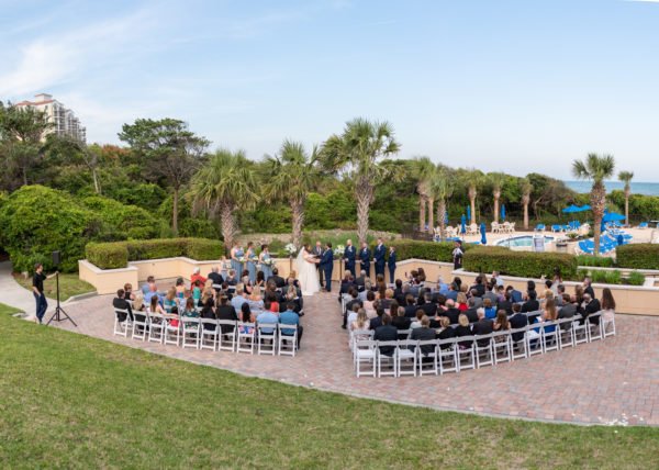 Panorama of wedding ceremony by the palm trees and pool - Grande Dunes Ocean Club