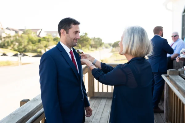 Mother helping groom with boutineer  - Pawleys Island Chapel